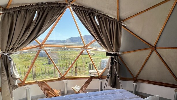 A room with a bed, curtains, and a view of a landscape. - Santerra, Guadalupe Valley (Valle de Guadalupe)