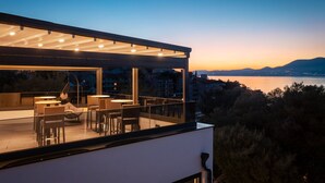 A modern house with a balcony overlooking a body of water and hills. - Beach Villa Valentina Apartment III (Okrug Gornji)