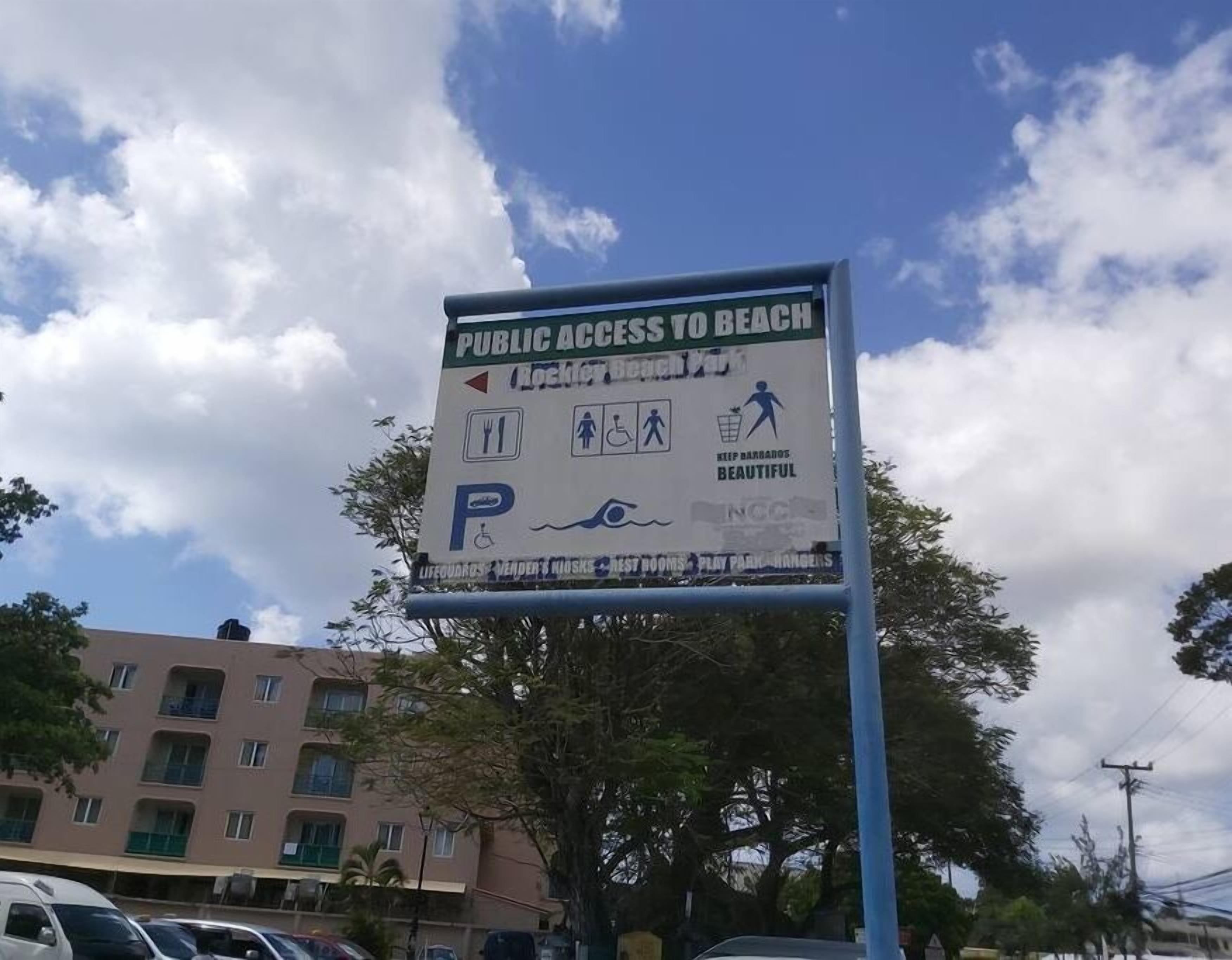 Un panneau indiquant que l’accès à la plage est libre et qu’elle dispose d’un parking et d’installations adaptées aux personnes handicapées.