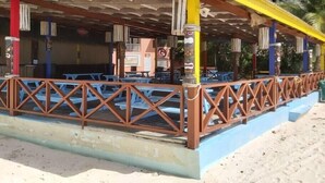A beachside restaurant with outdoor seating and a covered patio area. - Ocean View Apartment B with AC (Bridgetown)