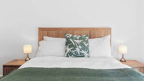 A bed with a wooden headboard, two bedside lamps, and a green throw blanket. - Apollo Bay Getaway (Apollo Bay)