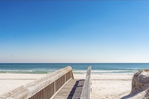 A wooden boardwalk leading to a sandy beach with a clear blue sky. - Beach View/Walk to White Sand/King Bed/Private Balcony/Gulf Shores, AL (Gulf Shores)