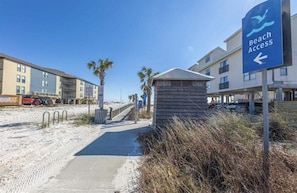 A beach access sign, a pathway leading to the beach, and a building with multiple balconies. - Beach View/Walk to White Sand/King Bed/Private Balcony/Gulf Shores, AL (Gulf Shores)