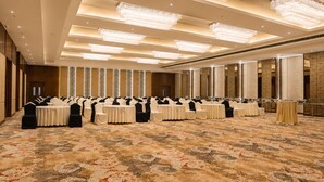 A large conference room with rows of tables and chairs, chandeliers, and a patterned carpet. - Park Inn By Radisson Ayodhya (Faizabad)