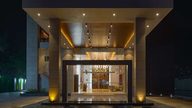 A modern building entrance with a glass facade, a central staircase, and a well-lit interior. - Park Inn By Radisson Ayodhya (Faizabad)