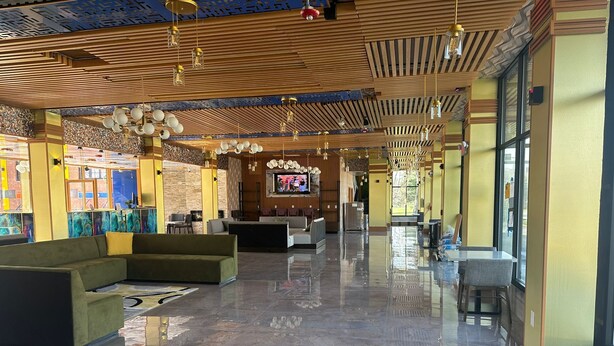 Un hall d’entrée spacieux, doté d’un sol en marbre poli, de meubles modernes et d’un grand écran de télévision.