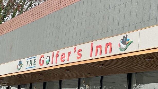 The exterior of The Golfer's Inn with a prominent sign and a logo.