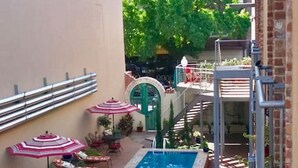 Un patio con piscina, mobiliario exterior y un muro de ladrillo.