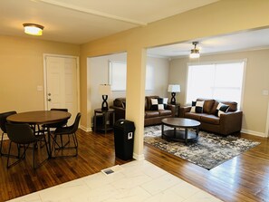 A living room with a dining table, two sofas, and a coffee table. - Nice Home in Quiet Neighborhood! (Center Point)