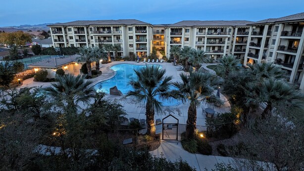 A hotel with a swimming pool surrounded by palm trees and a view of mountains. - The Hideout is a recently remodeled, fully wheelchair-accessible, luxury condo  (St. George)