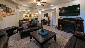 A living room with a leather couch, a coffee table, a flat-screen TV, and a fireplace. - The Hideout is a recently remodeled, fully wheelchair-accessible, luxury condo  (St. George)