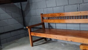A wooden bench against a grey brick wall, with a flat-screen TV mounted on the wall to the left. - Suíte maravilhosa Casa da Serra (Aurora do Tocantins)