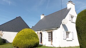 Un bâtiment blanc doté d’un toit à forte pente et d’une antenne parabolique.