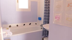 A bathroom with a bathtub, a window, and a shower curtain. - traditional Breton house (Belz)