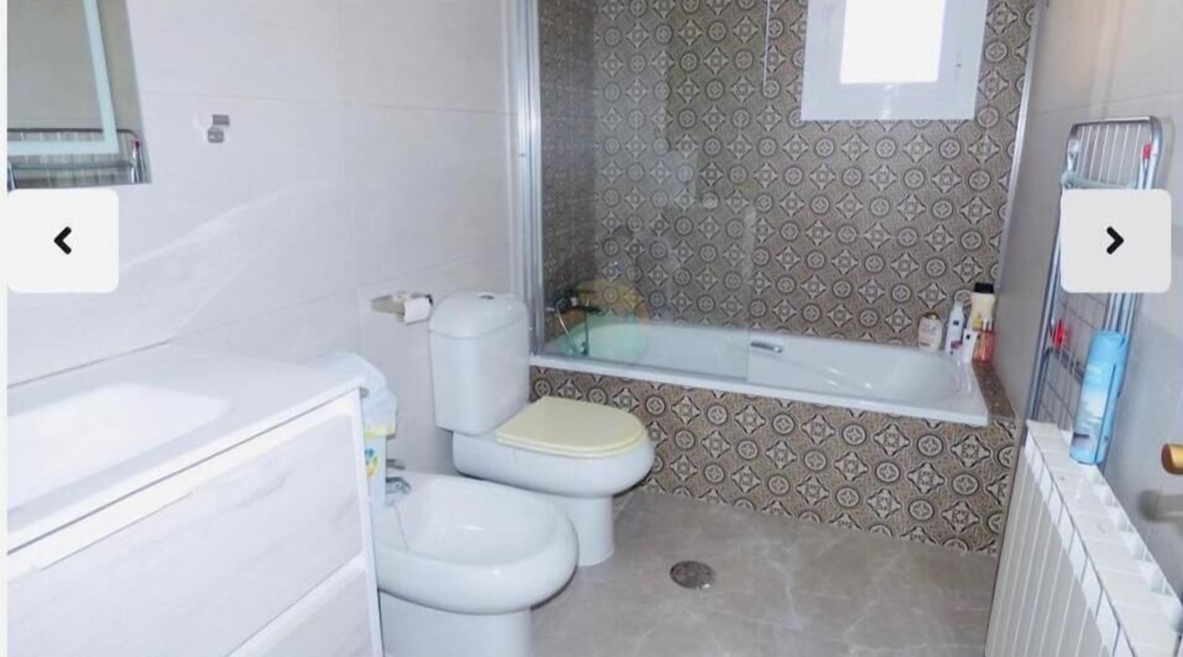 A bathroom with a toilet, bidet, and bathtub.