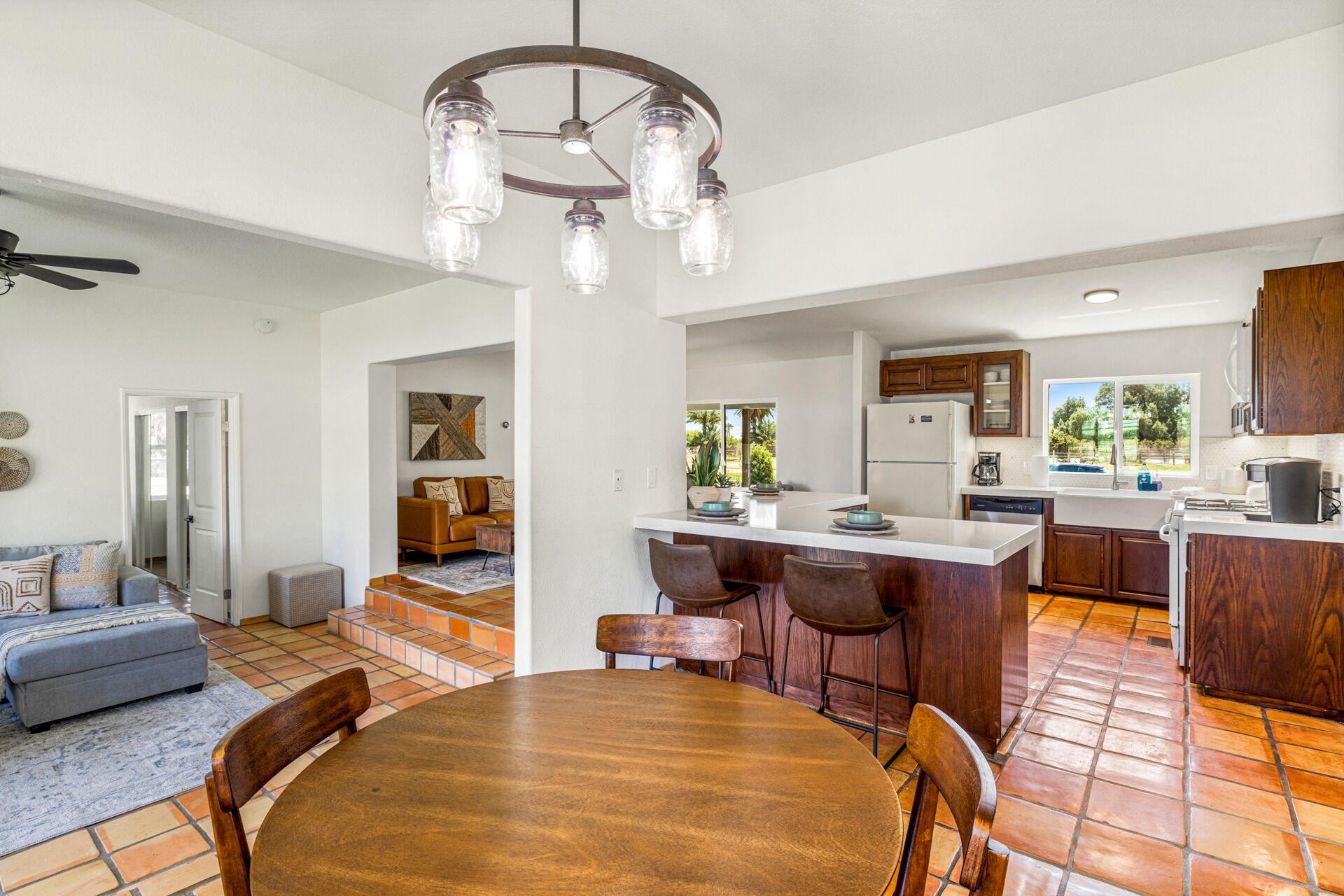Una cocina amplia con una isla central, armarios de madera y una lámpara de techo moderna.