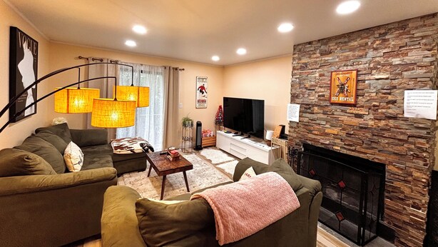 A cozy living room with a stone fireplace, a sofa set, and a flat-screen TV. - Cozy Ski On/Off Condo Located at Hunter Mountain (Hunter)