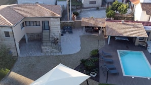 Propiedad residencial con piscina, zona de estar al aire libre y patio cubierto.