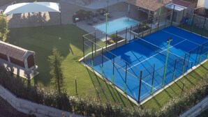 Un barrio residencial con piscina, terraza techada y una casa de piedra.