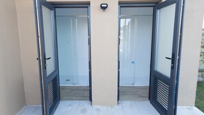 Un conjunto de puertas dobles con un panel de vidrio que dan acceso a un espacio interior con piso de madera.