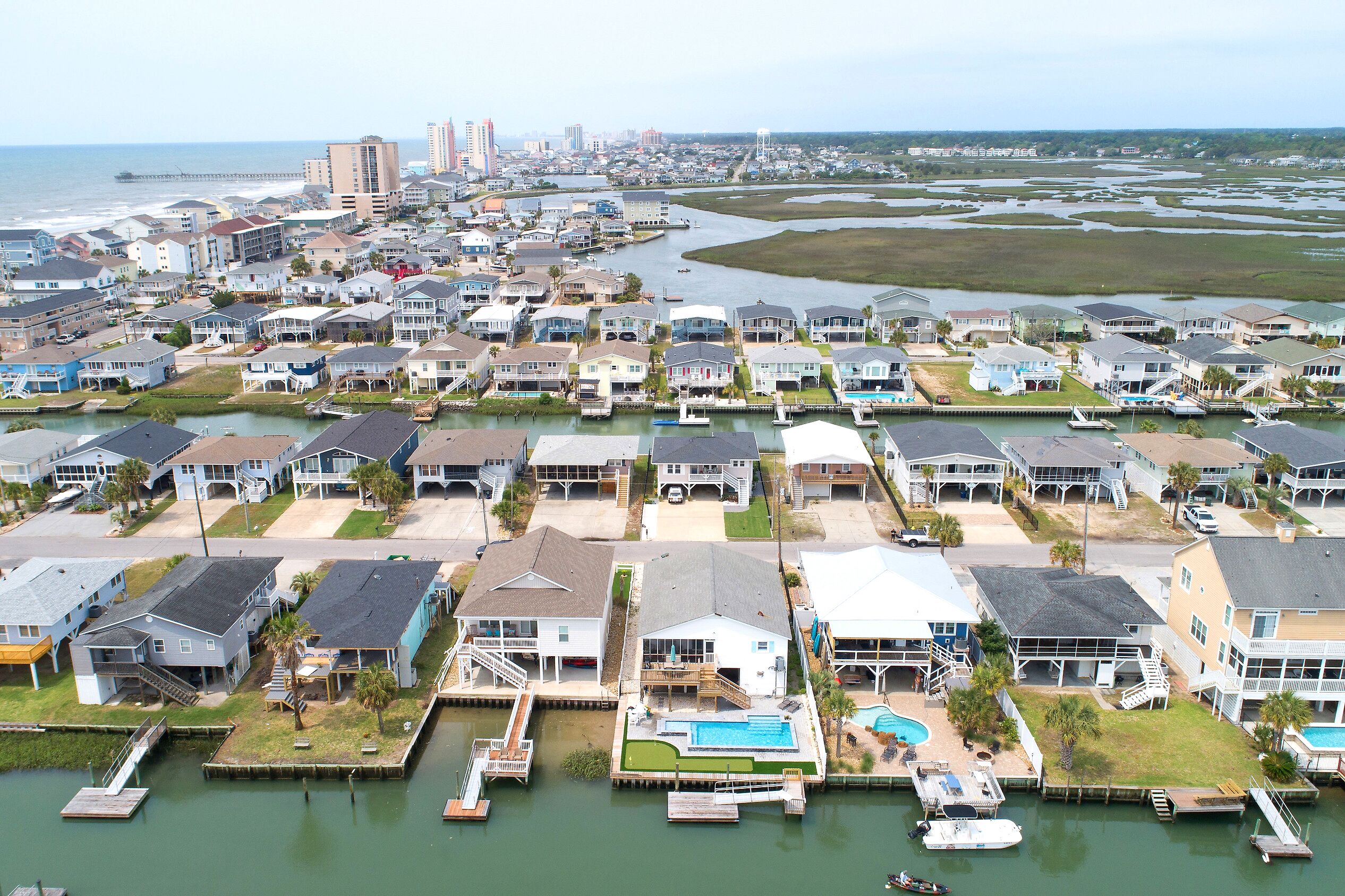 Zona residencial costera con casas, muelles y un puerto deportivo.