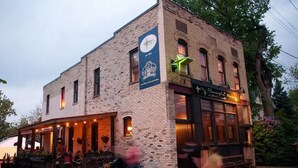 A brick building with a storefront and outdoor seating area. - Victorian Modern, on the Mississippi River (Minneapolis)
