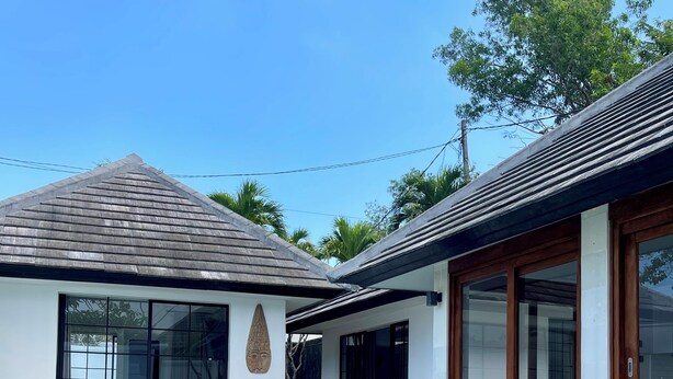 A modern house with a swimming pool, large windows, and a wooden deck. - 3 br villa across from Thomas beach, Uluwatu . (Pecatu, Bali)