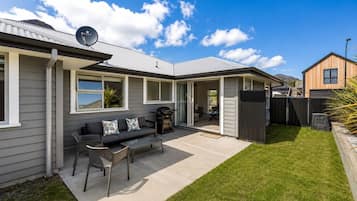 Un immobile residenziale con patio coperto, barbecue e parabola satellitare.