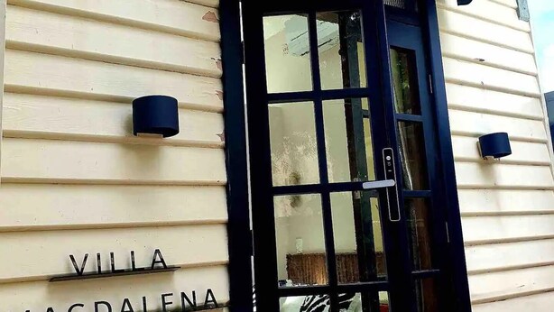 A building entrance with a black door and a striped awning. The words "VILLA MAGDALENA" are visible on the wall. - "Villa Magdalena" luxury studio (St Kilda)