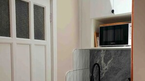 A compact kitchen with a built-in sink, a microwave, and a dishwasher. - "Villa Magdalena" luxury studio (St Kilda)