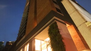 Um edifício moderno com uma característica arquitetônica triangular marcante, grandes janelas e uma entrada bem iluminada.