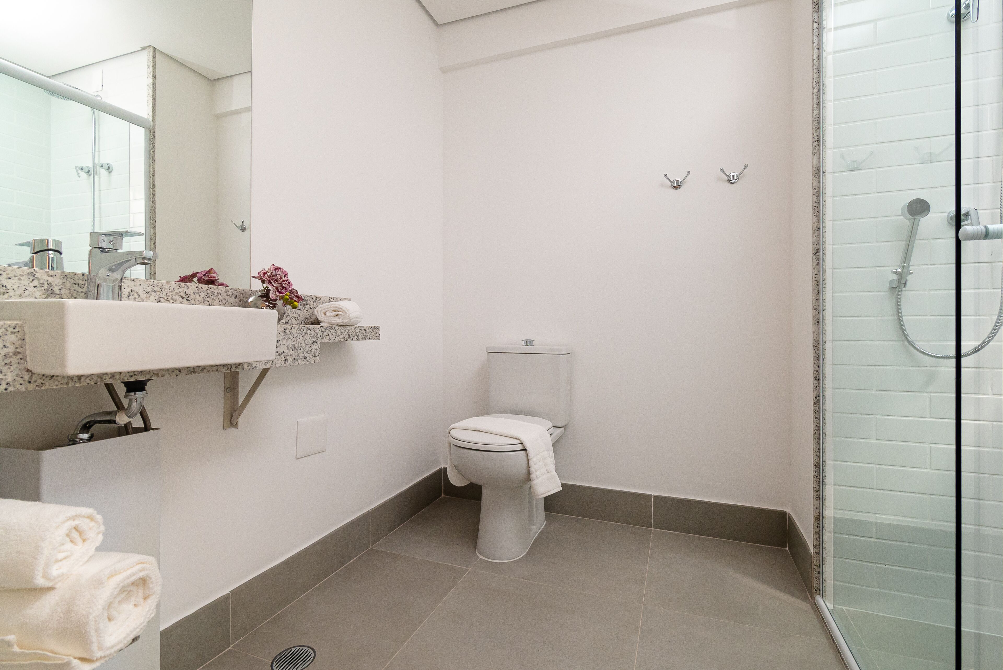 Un baño moderno con inodoro, lavabo y ducha.