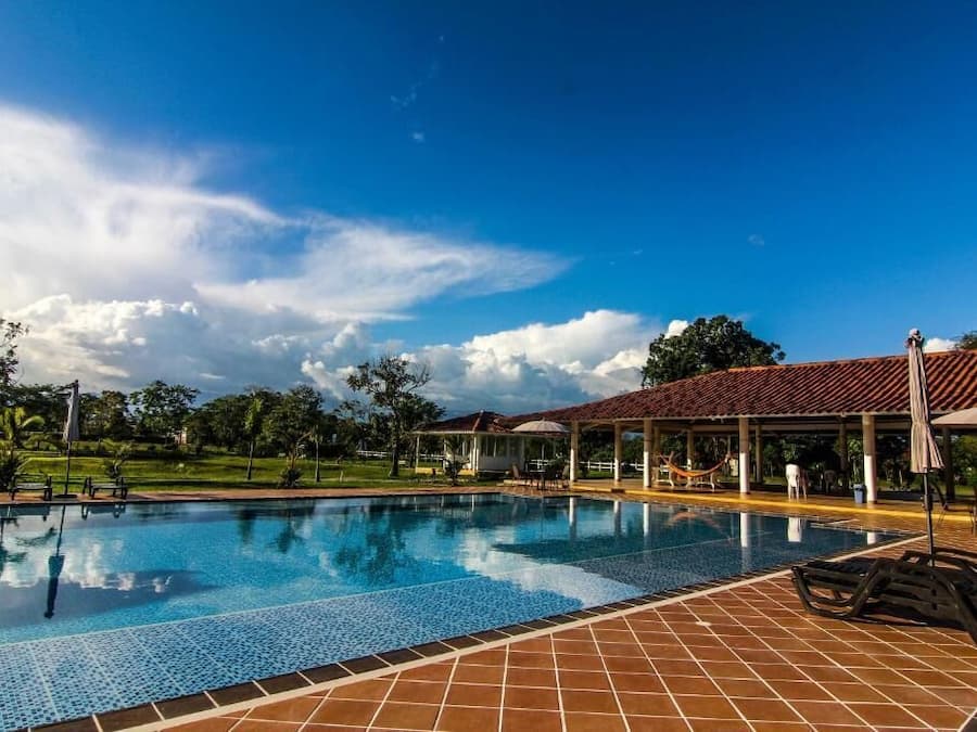 Una piscina al aire libre, sillones reclinables de piscina