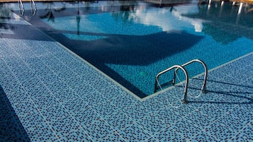 Una piscina al aire libre, tumbonas