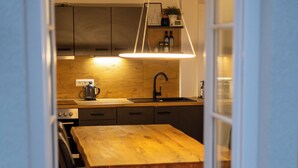 Une cuisine moderne avec une table et des chaises en bois, un luminaire suspendu et des placards intégrés.