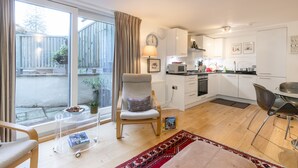 A modern apartment with a kitchen, dining area, and a large sliding glass door to the outside.
