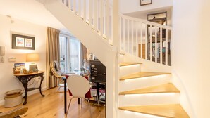 A staircase with wooden steps and white railings, leading to a second floor.