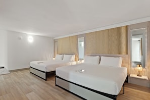 A hotel room with two beds, a wooden slat wall, a mirror, and a bedside table with a lamp. - Kompose Boutique Resort at Theme Parks (Kissimmee)