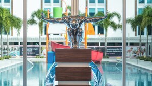 Zona de piscina con candelabro, estatua y vistas al exterior.