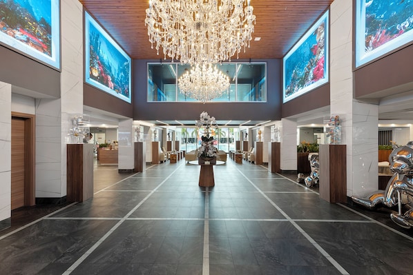 A spacious lobby with a large chandelier, seating areas, and large windows. - Kompose Boutique Resort at Theme Parks (Kissimmee)