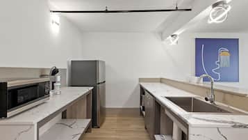 Una cocina moderna con encimeras de mármol blanco, electrodomésticos de acero inoxidable y un diseño minimalista.