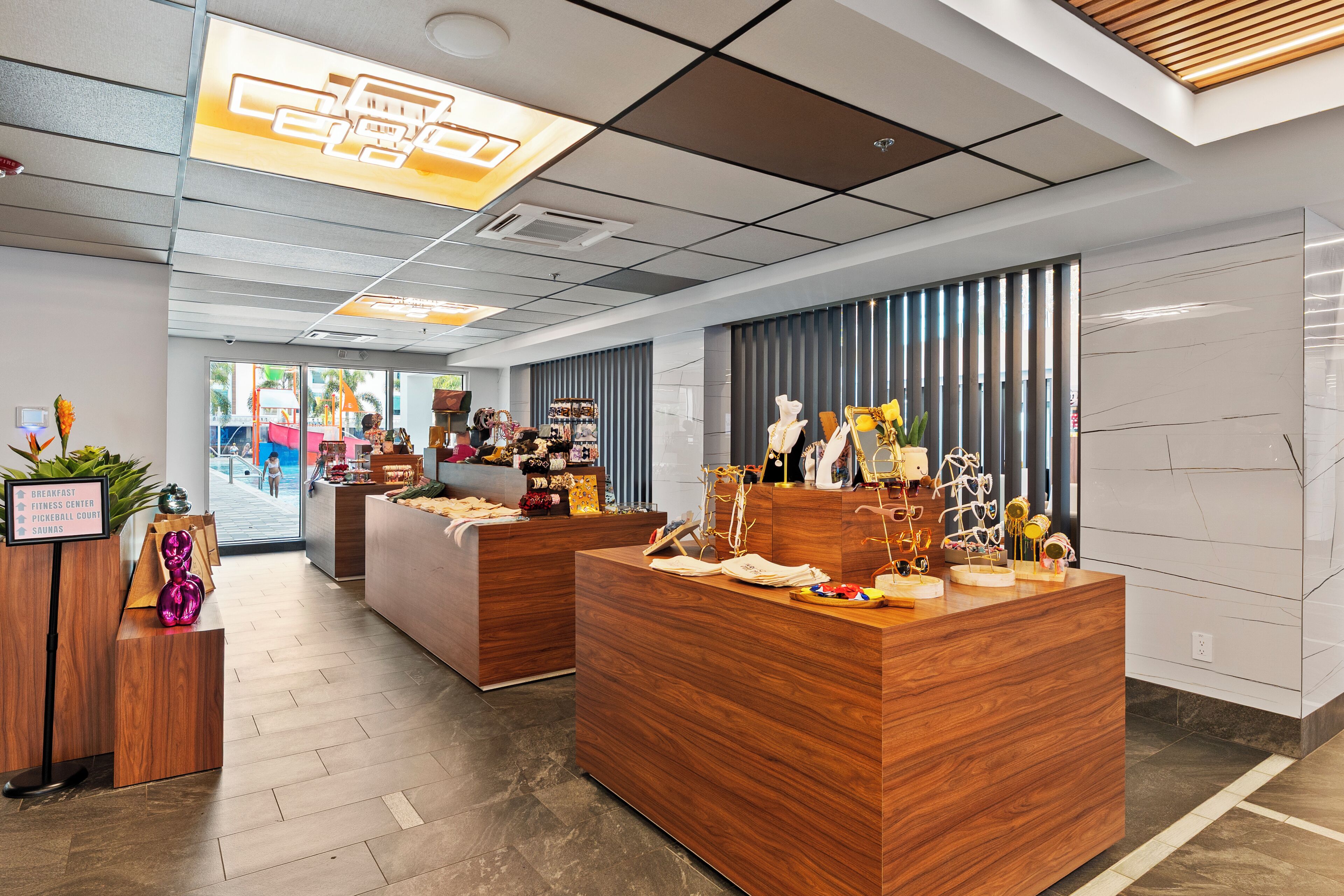 A modern reception area with wooden reception desks, a visible signboard, and a view of the outside.