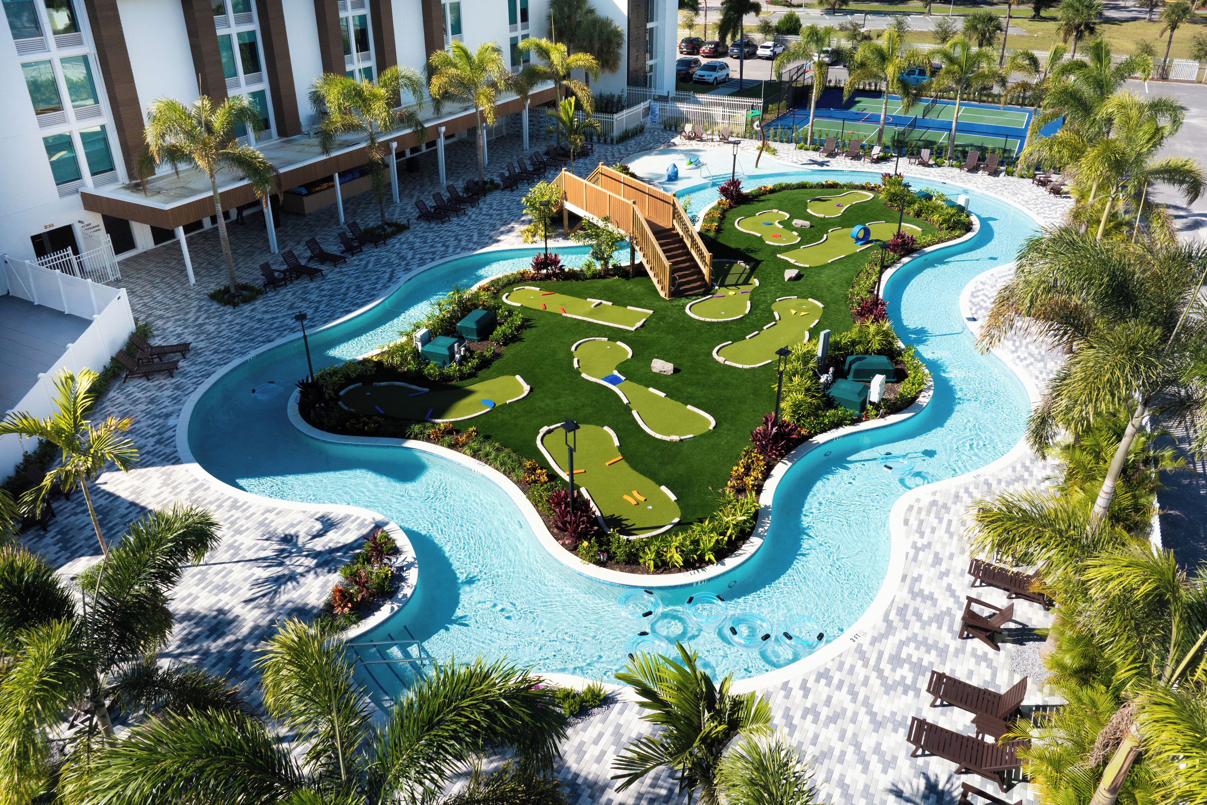 Una piscina al aire libre, sombrillas, sillones reclinables de piscina