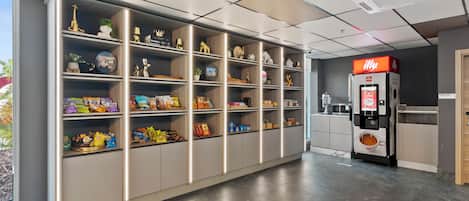 Cocina moderna con estante para aperitivos, máquina de café y vistas al exterior.
