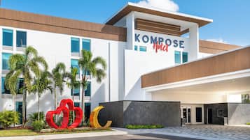 A modern hotel with a prominent sign reading "Kompose Hotel".
