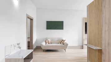 A minimalist living room with a sofa, a marble side table, and a wooden partition.