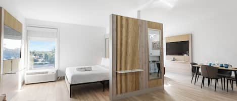 Une chambre d’hôtel moderne dotée d’un lit, d’un coin repas et offrant une vue sur l’extérieur.