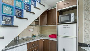 A compact kitchen with a washing machine, a microwave, and a refrigerator. - Vacation Apartment 'Dunaflor Gemelo 3' with Shared Pool, Wi-Fi and Air Conditioning (San Bartolomé de Tirajana)
