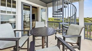 Un espace extérieur abrité doté d’un escalier en colimaçon, d’une table ronde et de quatre chaises.