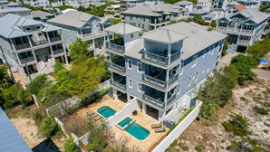 Un immeuble résidentiel à plusieurs étages, doté d’une piscine sur le toit et de nombreux balcons.